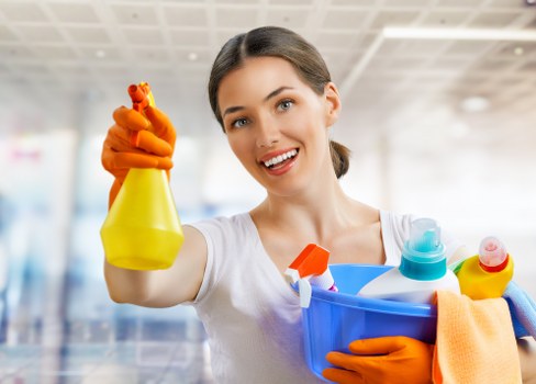 Professional cleaner vacuuming and dusting in a Kingston home